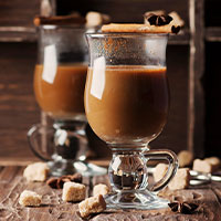 Jarro de vidrio con café sobre mesa rustica