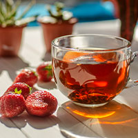 Taza de té con fresas rojas